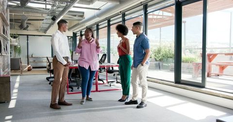 Happy Diverse Team Discussing Successful Project in Modern Office