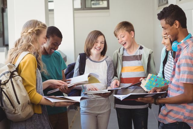 Group of smiling students standing with notebook in corridor - Download Free Stock Photos Pikwizard.com