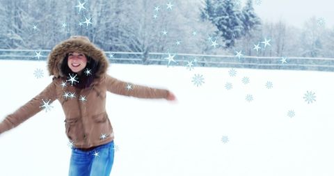 Joyful Woman Dancing in Falling Snow on Winter Day