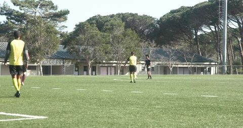 Soccer Players Practicing Teamwork on Sunny Day