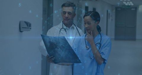 Medical team examining x-ray with digital hud overlay in hospital corridor