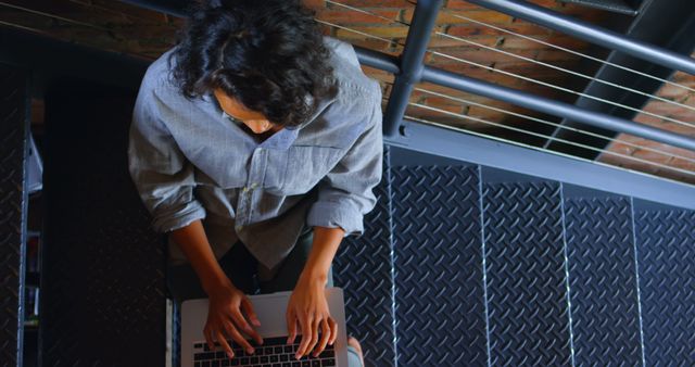 Top view of person typing on laptop keyboard on stairs - Download Free Stock Images Pikwizard.com