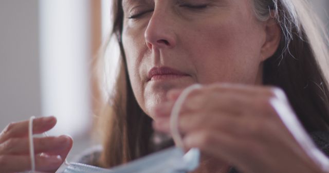 Senior Woman Putting on Face Mask for Safety - Download Free Stock Images Pikwizard.com