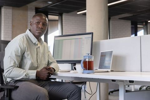 Professional African American Man Analysing Data in Modern Office