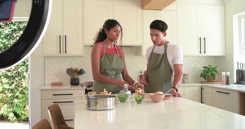African American Couple Cooking and Filming Together on Kitchen Island Using Ring Light
