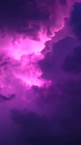 Vertical storm video with magenta backlighting revealing glowing violet thunderclouds