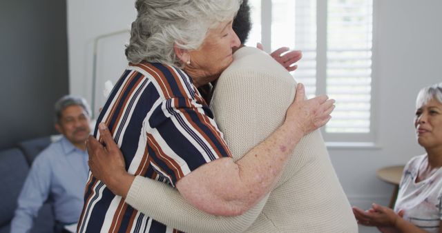 Senior Women Embracing with Friends in Background - Download Free Stock Images Pikwizard.com