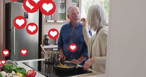 Senior Couple Enjoying Cooking Together with Social Media Heart Icons