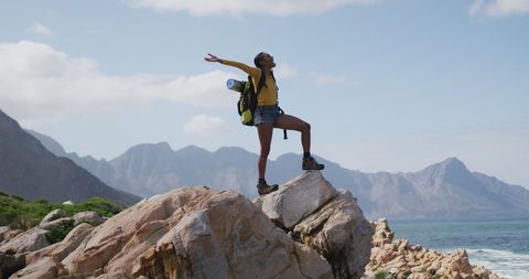 Woman Joyfully Hiking on Rock with Mountain View