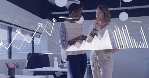 Business professionals collaborating over interactive analytics dashboard in modern office