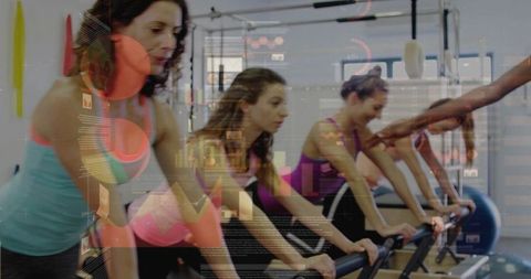 Women Practicing Pilates Reformer Class with Trainer Correcting Form in Studio