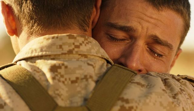 Tearful soldier embracing comrade in desert camo showing support, resilience, military brotherhood