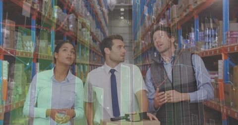 Warehouse team analyzing digital data projections amidst inventory