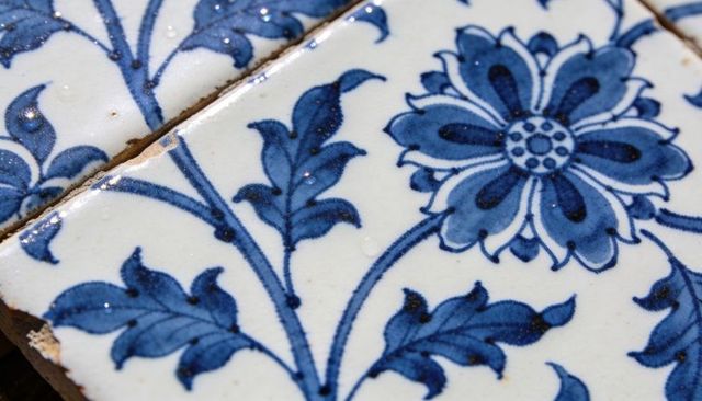Hand-painted cobalt blue floral ceramic tile featuring delft-style glaze and grout detail