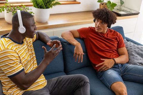 Two young men engaging in friendly conversation at home