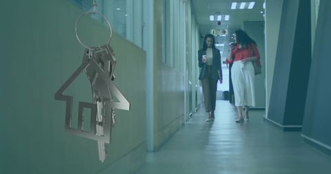 Real Estate Concept with Silver House Key and Businesspeople in Office Hallway - Download Free Stock Images Pikwizard.com