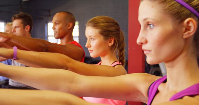 Group of Focused Individuals in Fitness Class Holding Arm Stretch - Download Free Stock Images Pikwizard.com