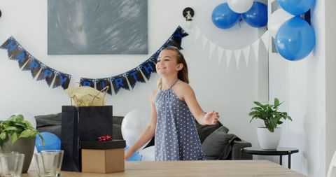 Young Girl Smiling at Birthday Party with Decorations and Gifts