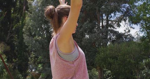 Caucasian Woman Practicing Yoga Outdoors with Greenery Background