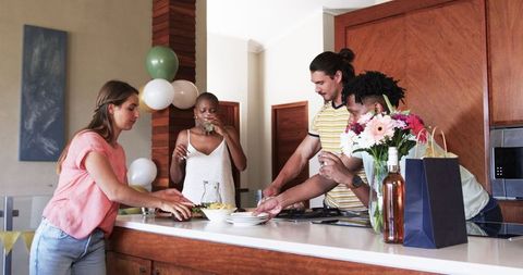 Diverse Group Enjoys Gatherings and Conversations in Modern Kitchen