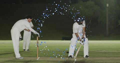 Night cricket batsman defending crease under floodlights with blue motion overlay