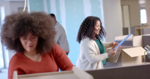 Diverse Team Unpacking Boxes in New Office Space