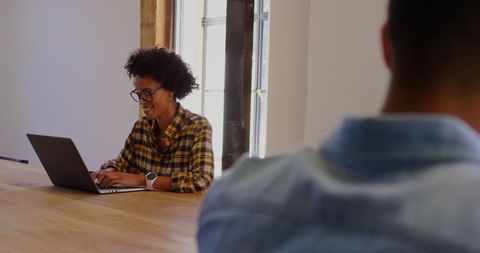 Smiling African American Businesswoman on Laptop in Modern Office