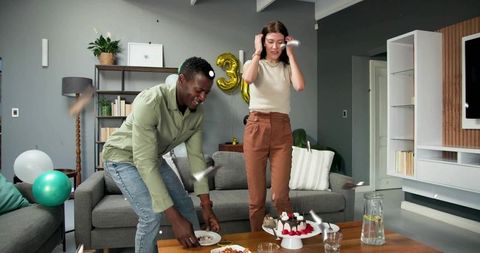 Couple celebrating birthday with cake and gold 3 balloon in contemporary living room party