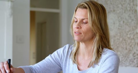 Woman in Casual Home Environment Serving Food with Focused Expression