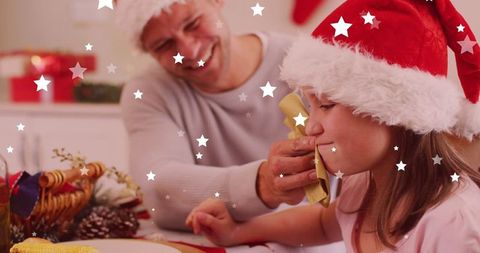 Joyful family sharing christmas eve dinner in santa hats