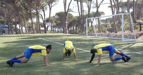 Soccer Players Warming Up on Green Field for Match Preparation