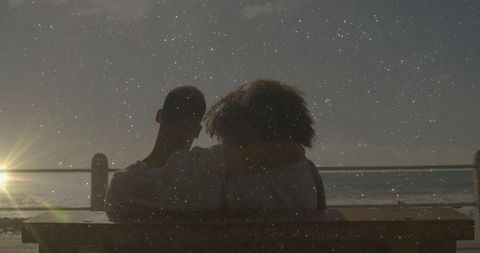 Romantic Couple Embracing on Beach Bench at Starlit Dusk