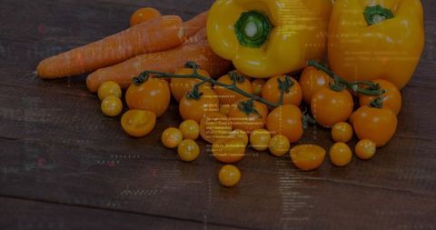 Displaying rustic yellow produce with cherry tomatoes, bell peppers, carrots on dark wood