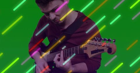 Musician Playing Electric Guitar Against Neon Backdrop