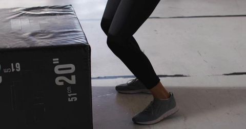 Athletic Woman Squatting Next to Plyobox at Gym