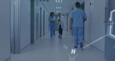 Medical team walking hospital corridor discussing patient records and collaboration