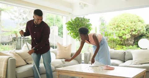 Couple Enjoying Cleaning Living Room Together