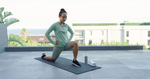 Woman Exercising on Rooftop Terrace with Scenery View