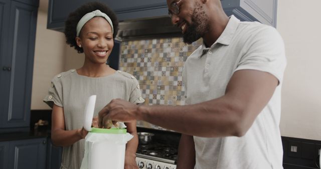 Happy african american couple composting vegetable waste in a kitchen - Download Free Stock Photos Pikwizard.com