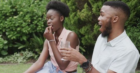 Joyful Couple Relaxing with Picnic in Lush Green Park