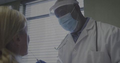 Doctor collecting swab in safety gear for medical diagnostic testing