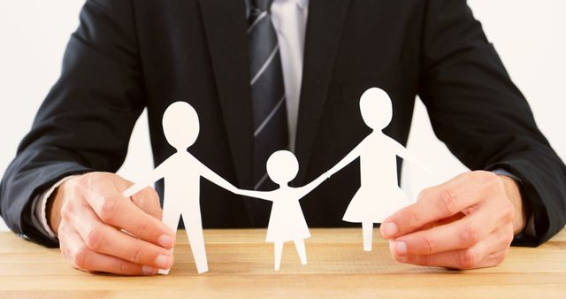 Businessman Holding Cutout Paper Family at Desk - Download Free Stock Images Pikwizard.com