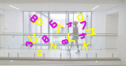 Active senior woman walking with prosthetic leg along glass corridor with colorful decals