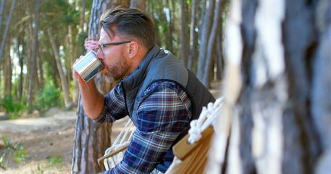 Man Relaxes Enjoying Drink in Tranquil Forest Adventure