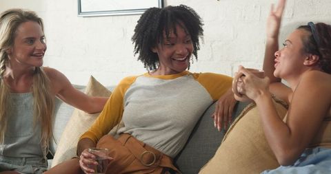 Diverse Female Friends Chatting and Relaxing on Sofa
