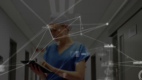 Doctor Using Tablet with Data Networks in Hospital Hallway