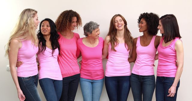 Happy women with pink shirts standing in a row - Download Free Stock Photos Pikwizard.com