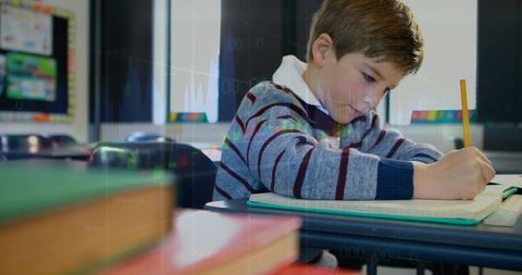 Young Student Writing in Classroom Focused on Task