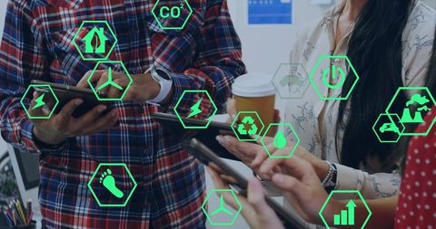Team collaborating with tablets and smartphones showing green sustainability icons