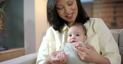 Mother Holding Infant Daughter in Cozy Home Environment